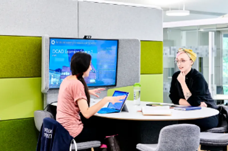 Two female members of staff looking at a laptop