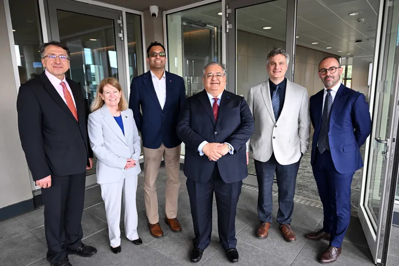 People dressed smartly, standing in a line, smiling at the camera