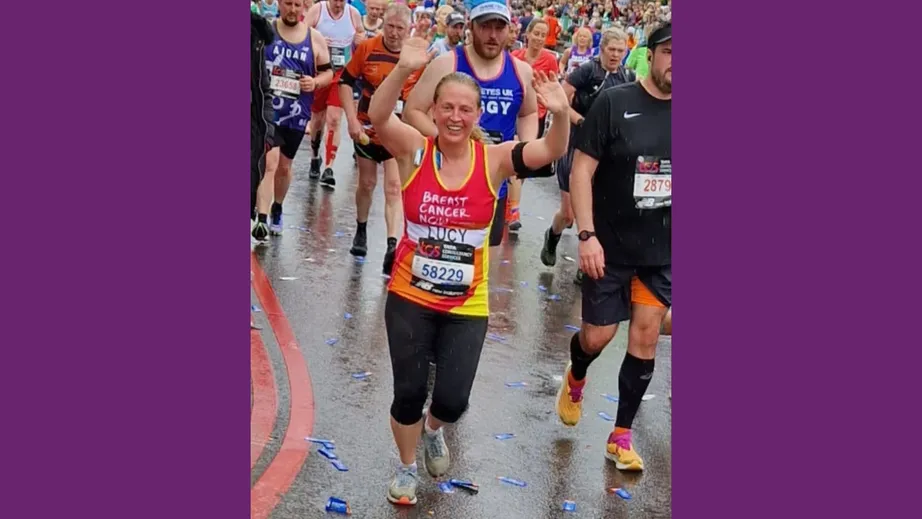 A woman running in a crowd whilst celebrating by throwing her arms in the air