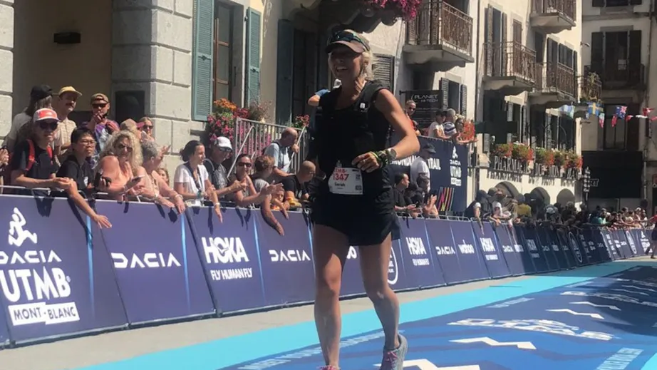 A women running towards the camera, towards the finish line of the UTMB