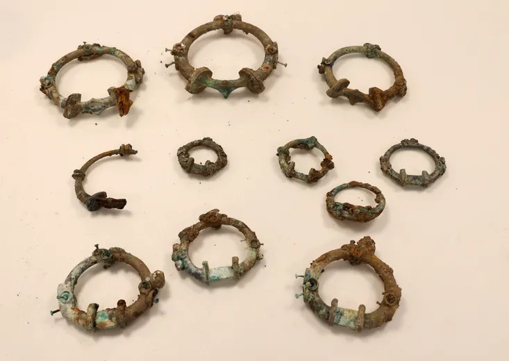 A group of metal rings of varying sizes, which have rusted and corroded in various places.