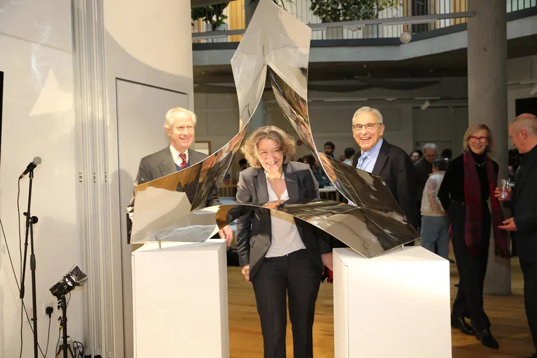 Three people looking at a sculpture