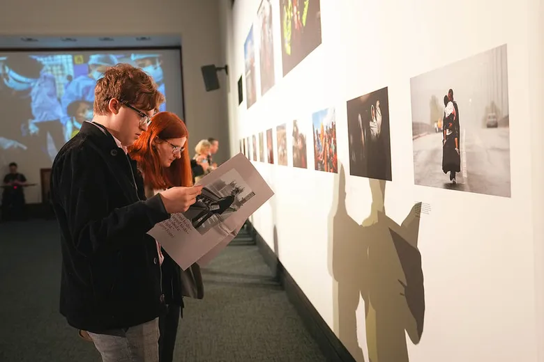 Two people reading a newspaper at the Summit