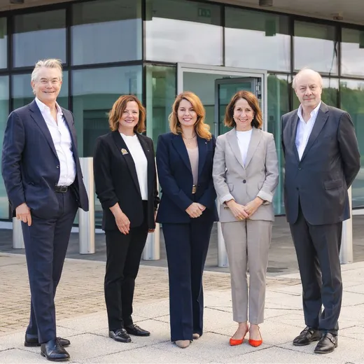 Two men and three woman standing outside an office building