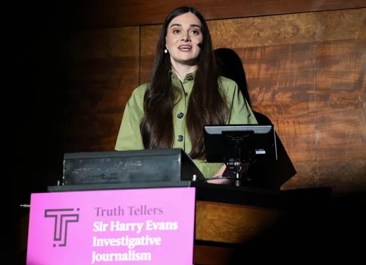 Woman standing behind lectern, giving speech