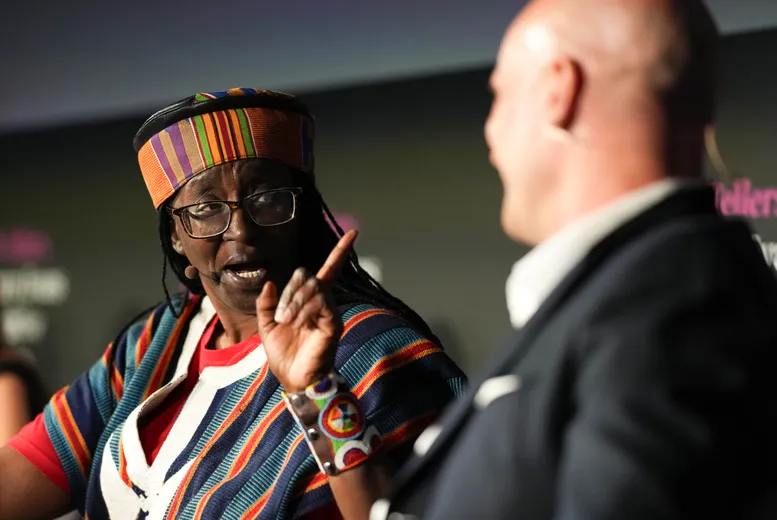 Woman sitting speaking to male, blurred, in foreground