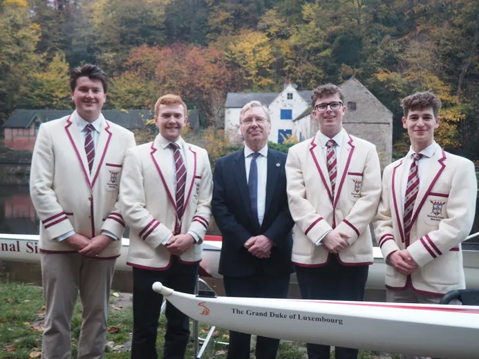 Five men in suits with a rowing boat