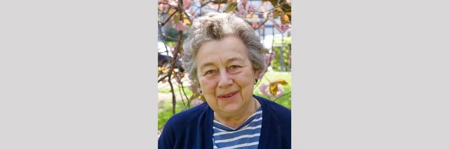 A portrait of Professor Dame Rosemary Cramp standing in front of a tree on a sunny day