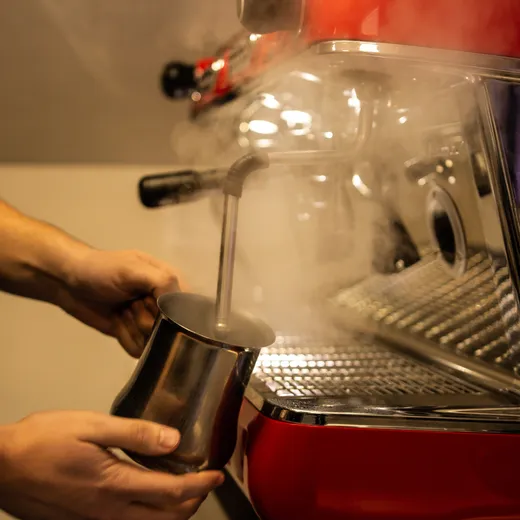 Frothing milk at coffee machine
