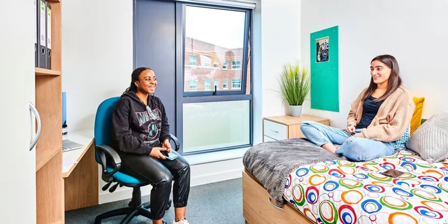 An image of two girls sitting in a town house room