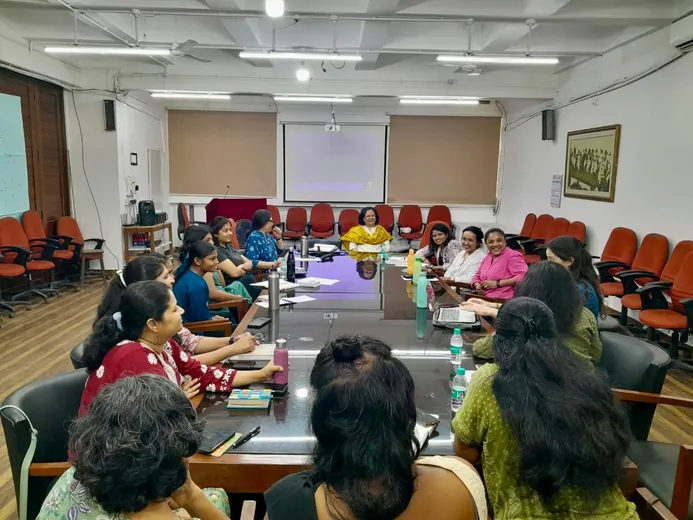Colleagues sat around large table in discussion