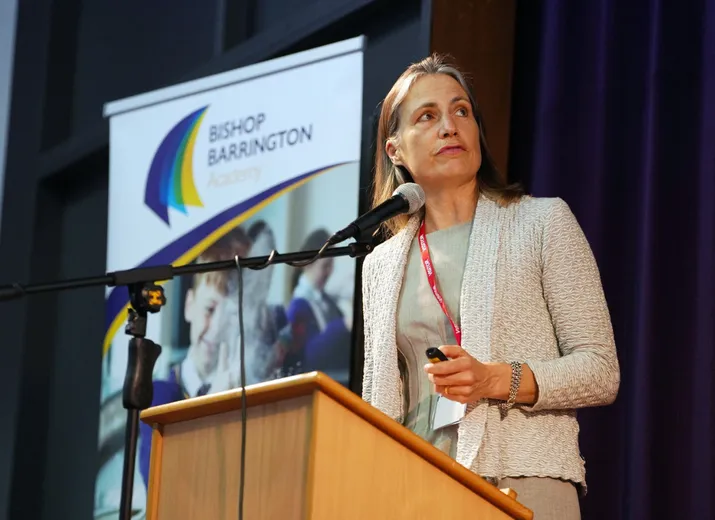 Dr Fiona Hill standing at a podium talking into a microphone