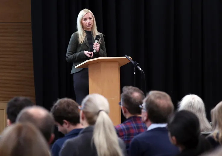 A woman talking in front of an audience