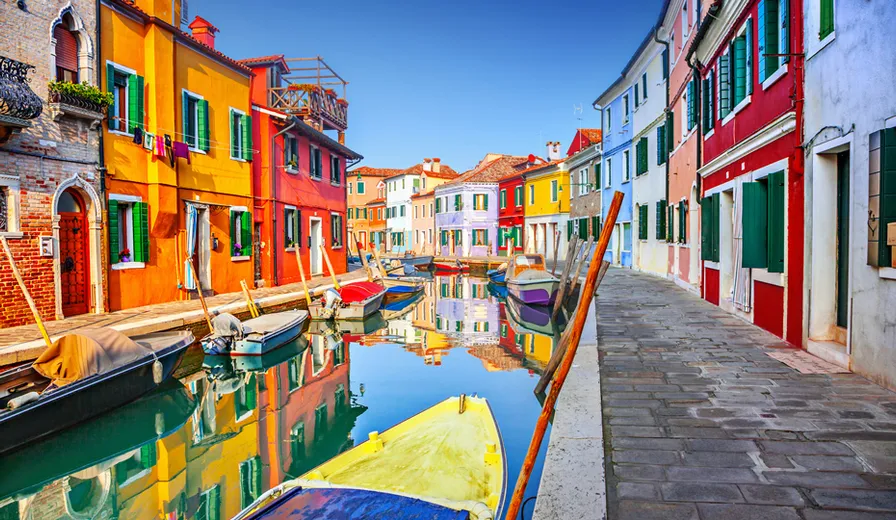 A canal in Burano, Italy lined with colourful buildings