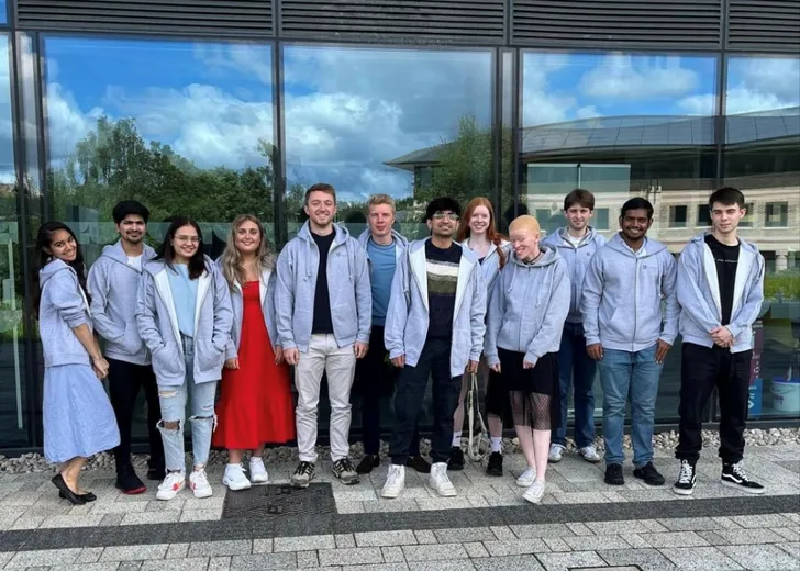 Group of students standing outside building wearing matching Venture Lab hoodies